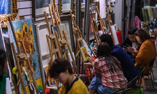 Du khách học vẽ tranh ở làng Dafen, Trung Quốc. Ảnh: Xinhua