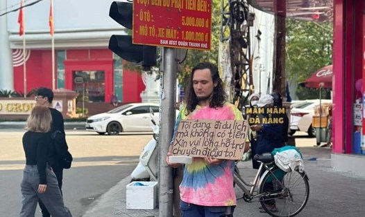 Du khách ngoại quốc cầm bảng xin tiền giữa trung tâm Đà Nẵng. Ảnh chụp màn hình