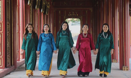 Du khách mặc áo dài tham quan Đại Nội Huế. Ảnh: Phúc Đạt.