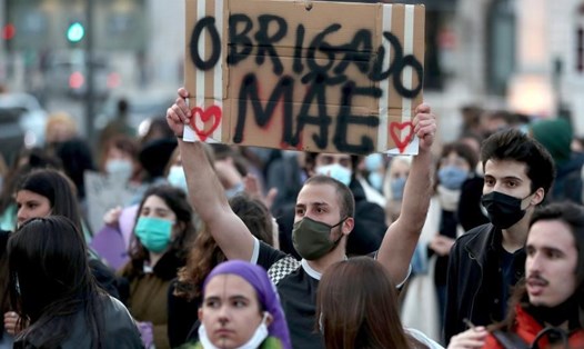 Một người đàn ông cầm tấm biển ghi "Cảm ơn mẹ" tham gia cuộc tuần hành kỷ niệm Ngày Quốc tế Phụ nữ ở Lisbon, Bồ Đào Nha, ngày 8.3.2021. Ảnh: Xinhua