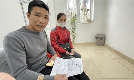 Anh Phạm Văn Tuyến cầm trên tay Giấy chứng tử của vợ để chuẩn bị làm thủ tục nhận chế độ tử tuất. Ảnh: Hà Anh