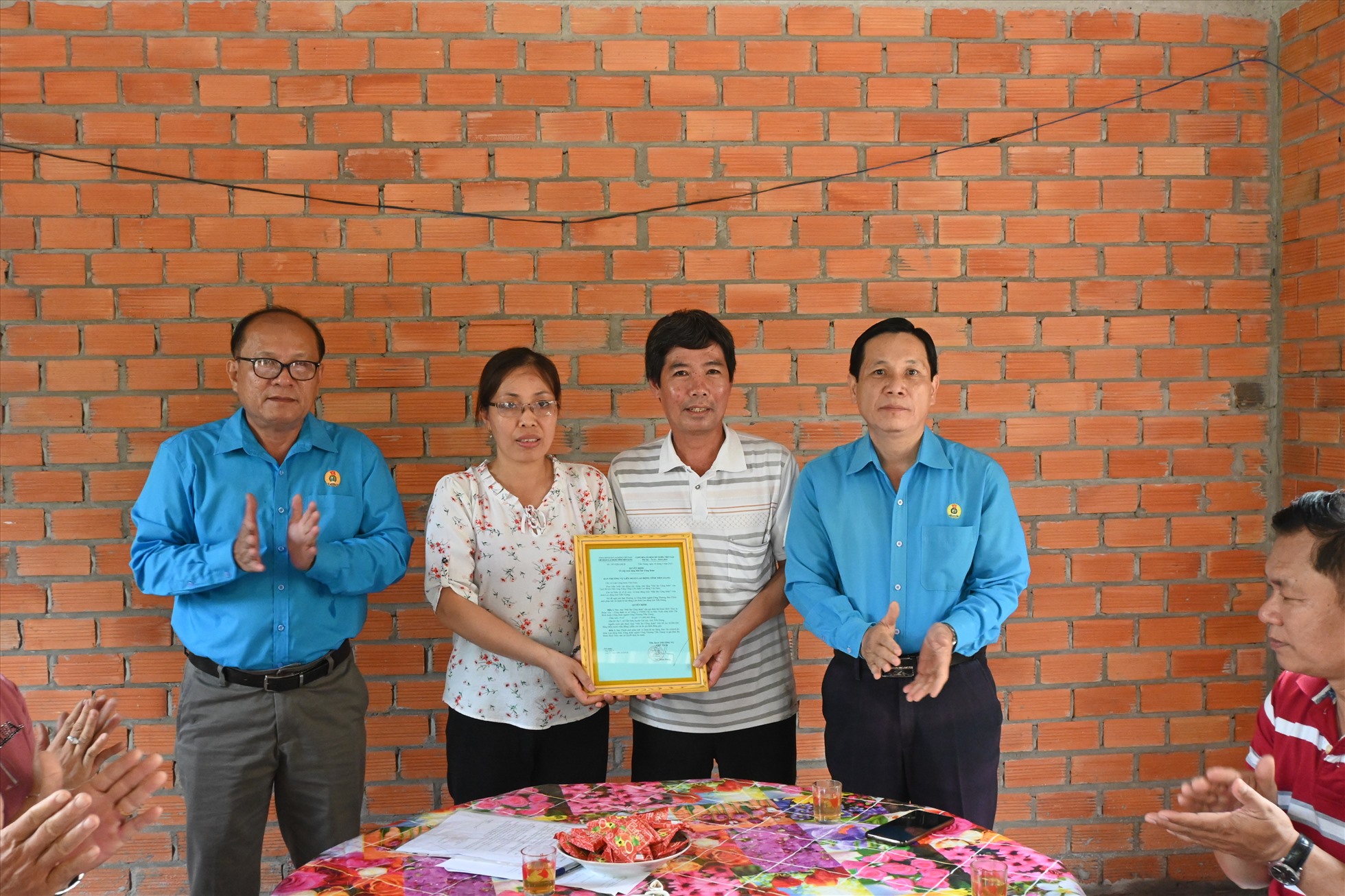 Chủ tịch LĐLĐ tỉnh Tiền Giang Lê Minh Hùng (ngoài cùng, bên phải) trao tặng "Mái ấm Công đoàn" cho chị Thủy. Ảnh: Thành Nhân