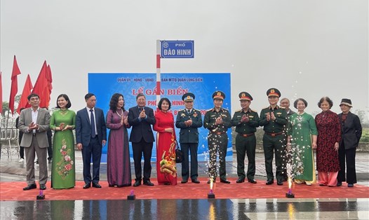 Đại diện lãnh đạo Bộ Quốc phòng, Tổng LĐLĐVN cùng gia đình thực hiện nghi thức gắn biển tên đường Đào Hinh. Ảnh: Thế Lâm
