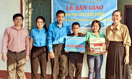 Liên đoàn Lao động huyện Trà Bồng bàn giao nhà và tặng gia đình một phần quà trị giá 500.000 đồng. Ảnh: Đinh Thị Ly