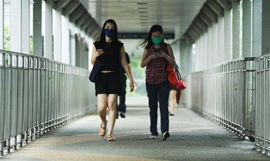 Mọi người đi bộ ở Singapore vào ngày 14.5.2021. Ảnh minh họa. Ảnh: AFP