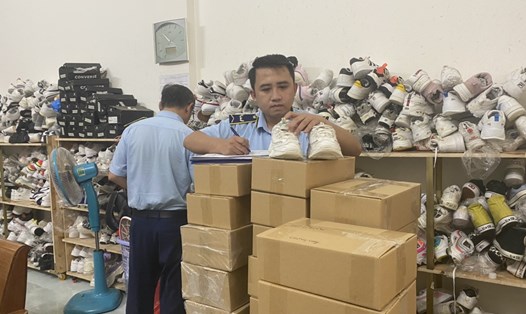 Lực lượng chức năng kiểm tra cơ sở kinh doanh đang bày bán hàng trăm sản phẩm giày thể thao không rõ nguồn gốc, xuất xứ ở TP Buôn Ma Thuột. Ảnh: B.Trung