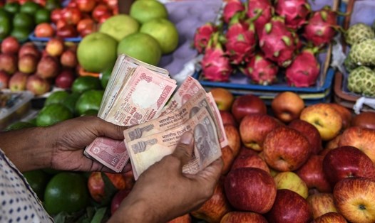 Người bán hàng rau quả ở Mumbai, Ấn Độ đếm tiền mặt. Ảnh minh hoạ: Xinhua