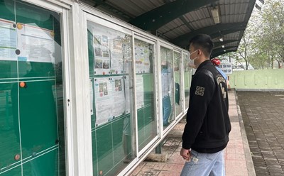 Công nhân đi tìm việc ở bảng tuyển dụng tại Khu công nghiệp Thăng Long. Ảnh: Minh Hương