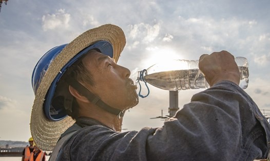 Công nhân uống nước tại công trường xây dựng ở Trung Quốc tháng 7.2022. Ảnh: Xinhua