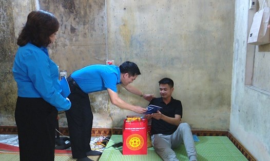 Ông Lê Đình Hùng - Phó Chủ tịch LĐLĐ thành phố Hà Nội tặng quà hỗ trợ công nhân Đàm Quang Huân. Ảnh: Ngọc Ánh