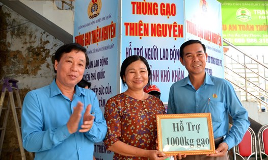 Chủ tịch LĐLĐ TP Phú Quốc Phan Xuân Trí (bìa phải) tiếp nhận hỗ trợ “Thùng gạo thiện nguyện”. Ảnh: Lục Tùng