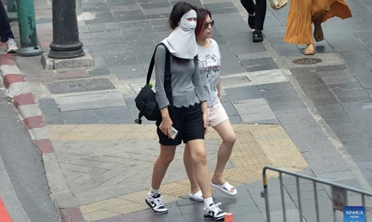 Người đi bộ đeo khẩu trang che nắng ở Bangkok, Thái Lan, ngày 19.4.2023. Ảnh: Xinhua