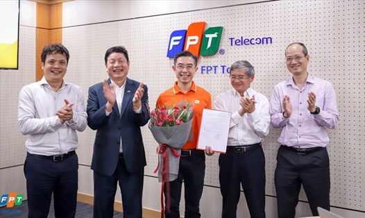 Tân Chủ tịch HĐQT FPT Telecom ông Hoàng Việt Anh (giữa) nhận quyết định đảm nhiệm vị trí mới từ ngày 25.4. Ảnh: FPT