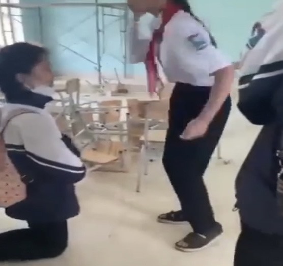 Một trường hợp nữ sinh ở Quảng Bình bị đánh phải quỳ dưới đất và không dám phản kháng. Ảnh cắt từ clip