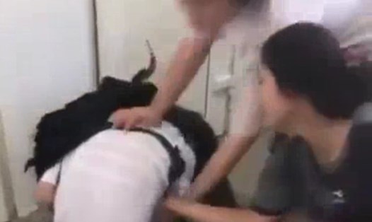 Nữ sinh đánh bạn học lớp 8 và tìm cách xé áo của nạn nhân. Ảnh chụp từ video.