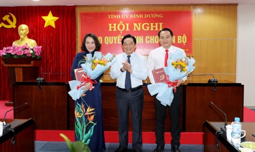 Ông Nguyễn Hoàng Thao trao quyết định và tặng hoa chúc mừng ông Trần Bảo Lâm và bà Trương Hải Thanh. Ảnh: UBND BD