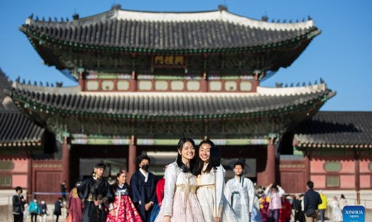 Du khách mặc trang phục Hanbok truyền thống chụp ảnh tại Cung điện Gyeongbokgung ở Seoul, Hàn Quốc. Ảnh minh họa: Xinhua