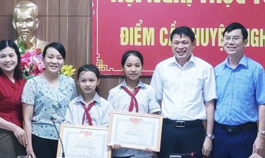 Tặng giấy khen cho hai nữ sinh lớp 6 dũng cảm cứu em bé đuối nước. Ảnh: Quỳnh Trang