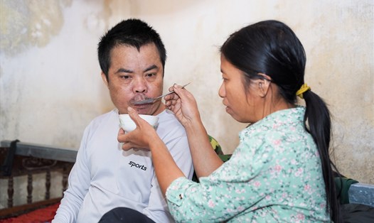 Hơn 4 năm qua, chị Bình luôn bên cạnh chăm sóc cho chồng bại liệt. Ảnh: Phạm Thông