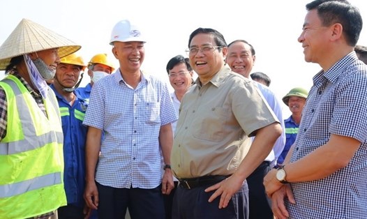 Thủ tướng Chính phủ nói chuyện với lãnh đạo tỉnh Thanh Hóa và công nhân trên công trường. Ảnh: Minh Hiếu
