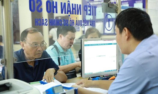 Cán bộ BHXH TP.Hà Nội hướng dẫn người dân hoàn thiện hồ sơ BHXH. Ảnh: Hải Nguyễn