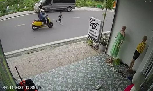 Hình ảnh ghi lại người đàn ông mặc đồ đen bất cẩn khi dẫn con qua đường, khiến con va chạm với xe môtô vàng. Ảnh cắt từ clip