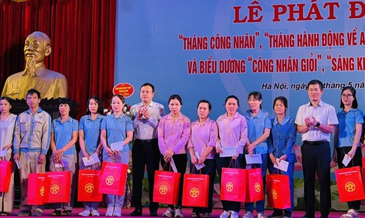 Chủ tịch Liên đoàn Lao động Thành phố Hà Nội Phạm Quang Thanh (thứ 6 từ trái sang) trao hỗ trợ cho công nhân lao động khó khăn Các khu công nghiệp và chế xuất Hà Nội. Ảnh: Kiều Vũ