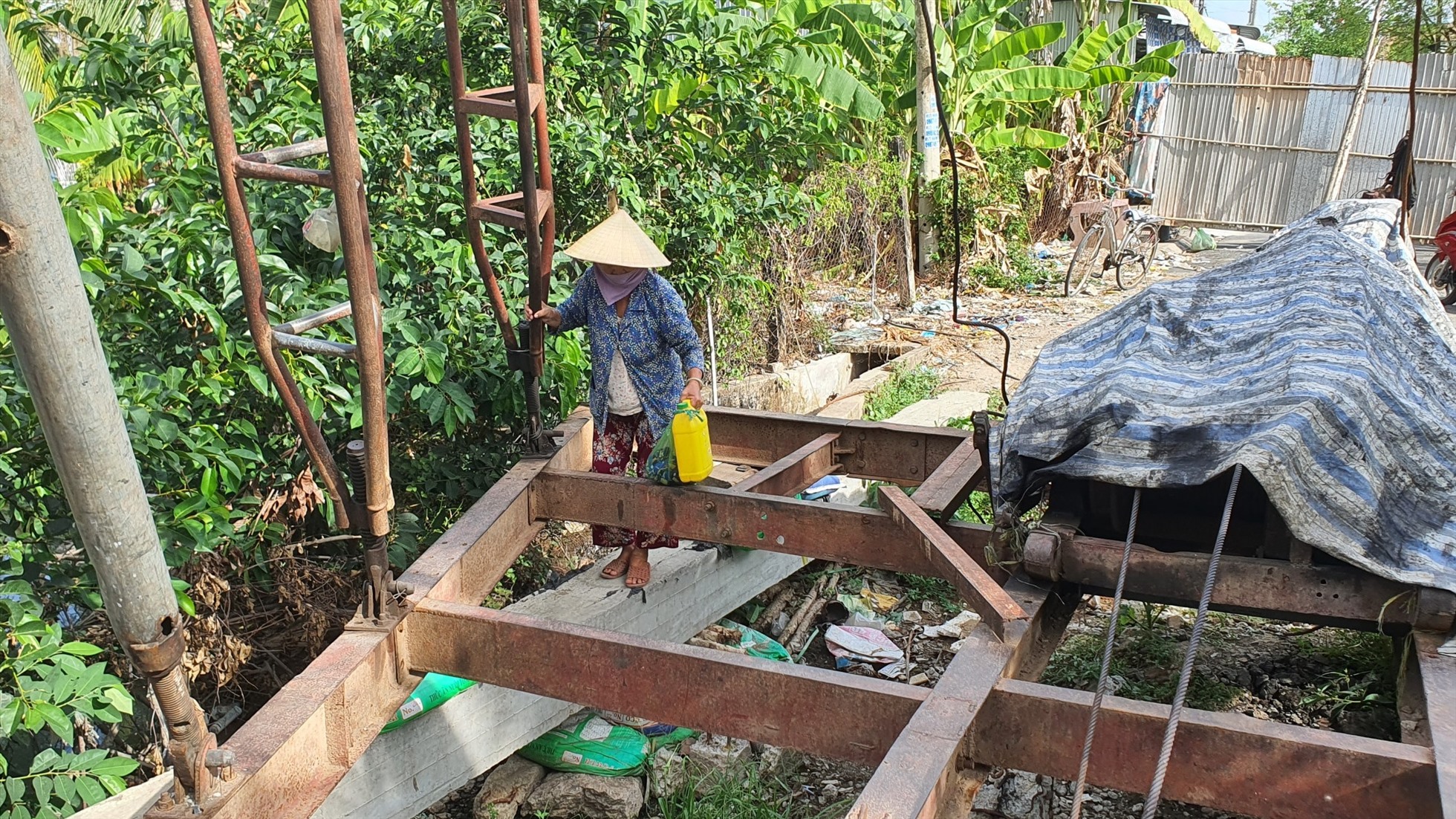 Cầu làm mãi không xong, không có cầu tạm người dân hàng ngày lần mò qua công trình để qua lại. Ảnh: Nhật Hồ