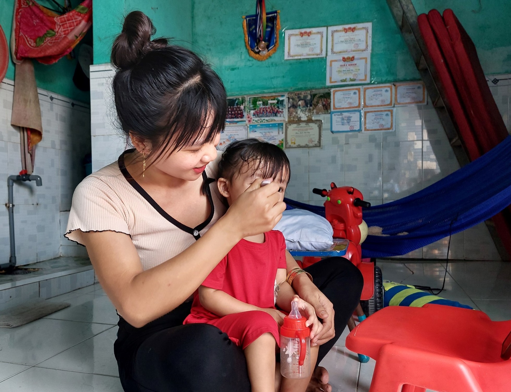 Chị Phùng Thị Vui - Công nhân Cty PouYuen cho con ăn tại phòng trọ. 
Ảnh: Phương Ngân