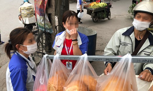 Công nhân Khu công nghiệp Quang Châu (huyện Việt Yên, tỉnh Bắc Giang) mua đồ ăn sáng tại xe hàng rong sau khi kết thúc ca làm việc ban đêm. Ảnh: Bảo Hân