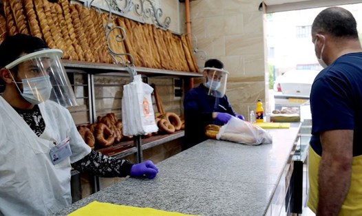Nhân viên cửa hàng bán bánh mì tại một tiệm bánh ở Constantine, Algeria trong đại dịch COVID-19. Ảnh: Tổ chức Lao động Quốc tế