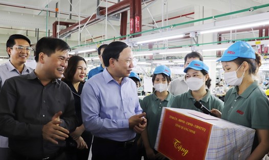 Bí thư Tỉnh ủy Nguyễn Xuân Ký tặng quà cho các công nhân đang làm việc tại Công ty TNHH May mặc Hoa Lợi Đạt. Ảnh: Thu Chung