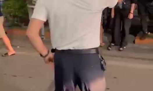 Người đàn ông mặc áo trắng trong clip được xác định là Trưởng Công an phường Bãi Cháy. Ảnh cắt từ video clip