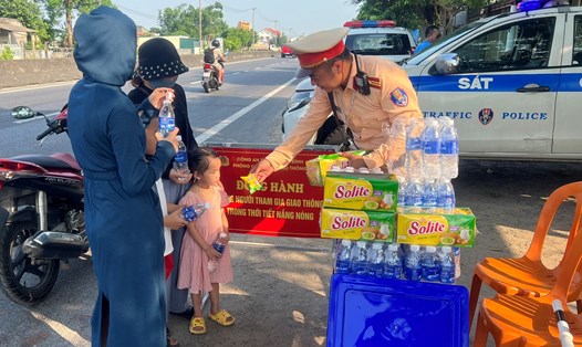 Những phần sữa, nước, bánh kẹo được lực lượng CSGT - Công an tỉnh Quảng Bình phát tận tay người dân trong tiết trời nắng nóng. Ảnh: Lê Phi Long