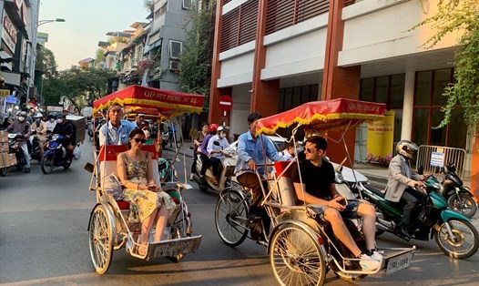 Khách du lịch nước ngoài đến Việt Nam trải nghiệm ngồi xích lô. Ảnh: Ý Yên