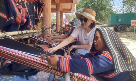 Khách du lịch khám phá vẻ đẹp thổ cẩm, may mặc của người Jrai. Ảnh: Thanh Tuấn