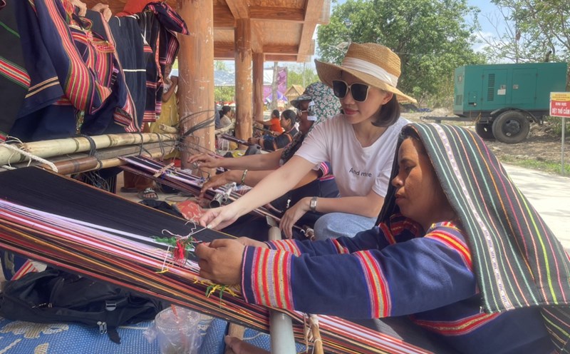 Khách du lịch khám phá vẻ đẹp thổ cẩm, may mặc của người Jrai. Ảnh: Thanh Tuấn