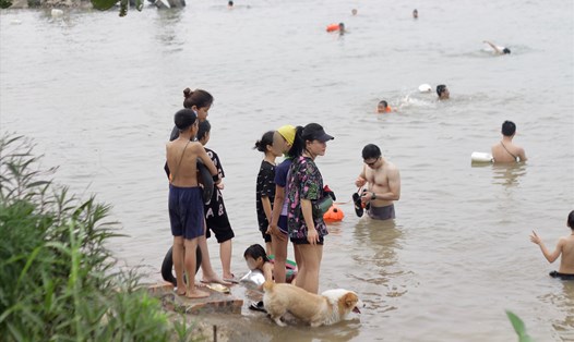 Người dân đổ xô ra bãi tắm tự phát ven sông Hồng tại phường Ngọc Thụy, quận Long Biên. Ảnh: Minh Hồng