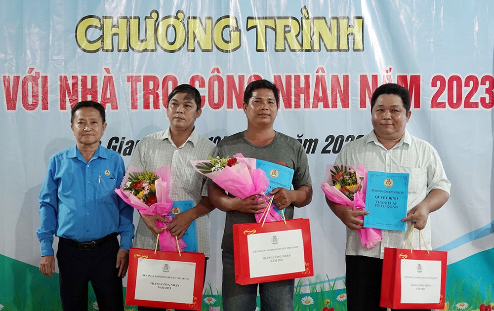 Chủ tịch Liên đoàn Lao động huyện Thoại Sơn - ông Đỗ Ngọc Nam - trao hoa và quà cho Tổ tự quản nhà trọ công nhân. Ảnh: Kim Anh