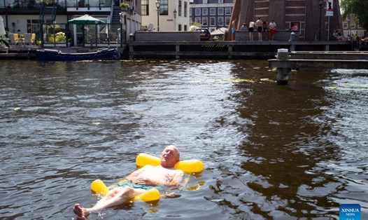 Người đàn ông giải nhiệt trong nước trong đợt nắng nóng ở Haarlem, Hà Lan năm 2022. Ảnh: Xinhua