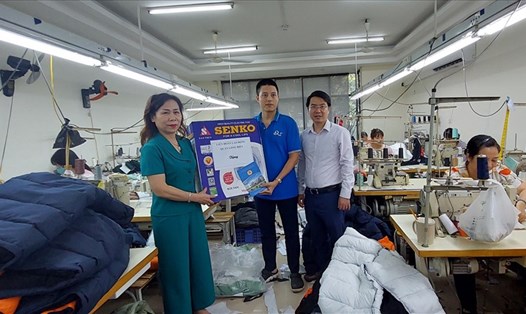 Chủ tịch Liên đoàn Lao động quận Long Biên Phan Thị Thu Hằng trao quà hỗ trợ công nhân lao động tại dây chuyền sản xuất nhân Tháng Công nhân. Ảnh: CĐCS