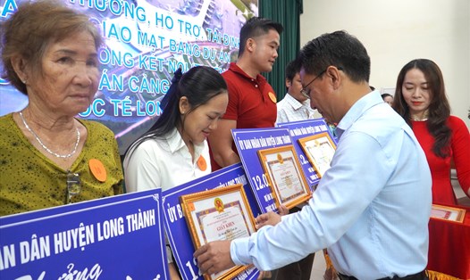 Chủ tịch UBND huyện Long Thành Lê Văn Tiếp trao giấy khen cho các hộ dân chấp hành tốt chính sách giải phóng và bàn giao mặt bằng. Ảnh: Hà Anh Chiến