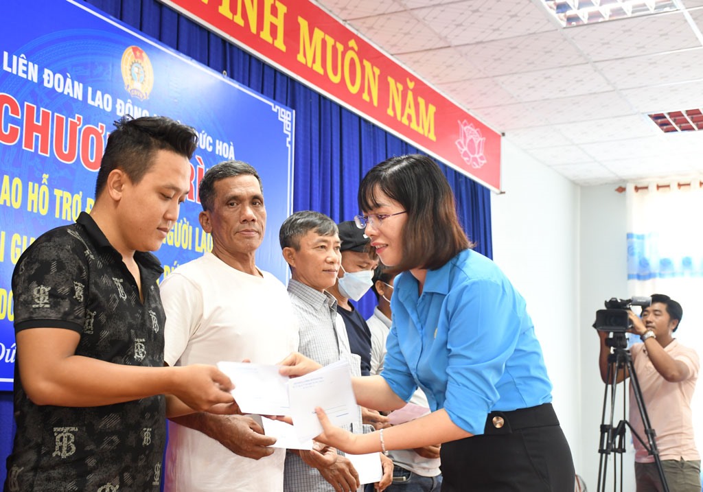 Đại diện LĐLĐ huyện Đức Hòa trao tiền hỗ trợ. Ảnh: An Long