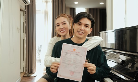 Hồ Quang Hiếu và bà xã khoe giấy chứng nhận kết hôn. Ảnh: Nghệ sĩ cung cấp.