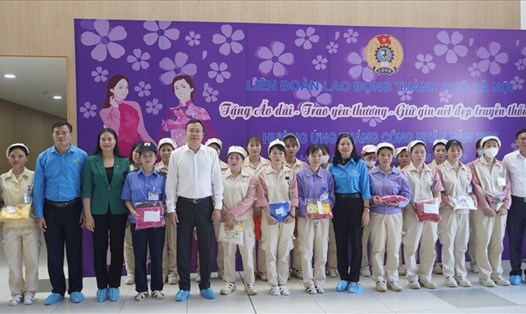 Lãnh đạo Liên đoàn Lao động thành phố Hà Nội trao tặng áo dài cho công nhân. Ảnh: Mai Quý