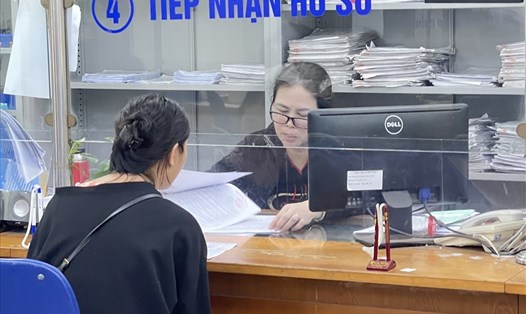 Cán bộ bảo hiểm xã hội thành phố Hà Nội trả lời thắc mắc của người lao động về chế độ bảo hiểm xã hội. Ảnh: Hà Anh