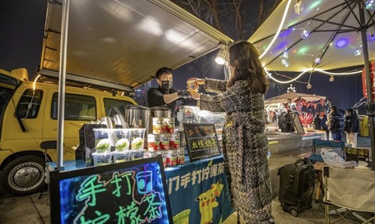 Một người bán hàng rong bán đồ uống tại thành phố Trùng Khánh của Trung Quốc. Ảnh: Xinhua