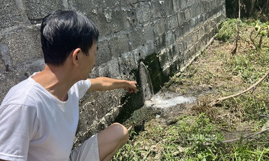 Dòng nước thải từ trại lợn vẫn chảy ra ngoài dẫu cho yêu cầu dừng hoạt động đã được ban hành. Ảnh: Minh Nguyễn
