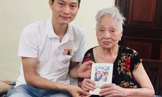 Tác giả Kiều Mai Sơn tặng sách tới cụ Đỗ Thị Phương là mẹ của bà Nguyễn Thị Quỳnh Dung - thiếu nhi có 7 tấm ảnh được chụp cùng Bác Hồ. Ảnh: Ái Vân