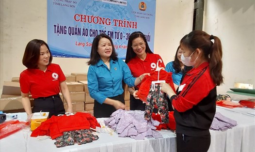 Bà Bế Thị Hoà - Phó Chủ tịch Thường trực LĐLĐ tỉnh Lạng Sơn (thứ 2 từ trái sang) trao tặng quần áo trẻ em cho nữ đoàn viên. Ảnh: Công đoàn Lạng Sơn